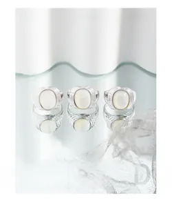 Macro detail of S925 silver rings with white oval mother of pearl and ribbed texture