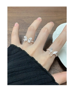 Detail of S925 sterling silver butterfly rings with textured finish on fingers