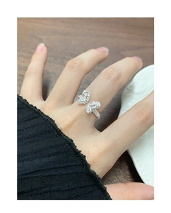 Detail of silver S925 butterfly ring featuring textured wings on female finger