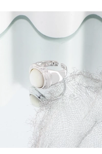 Macro detail of silver oval mother of pearl signet ring with textured bezel setting