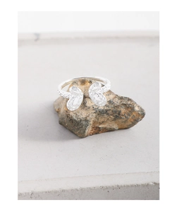 Macro shot of silver butterfly ring with hammered texture on a natural stone base