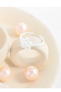 Close-up of S925 sterling silver flower ring with white pearl on ceramic stand