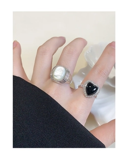 Close-up of S925 silver rings featuring oval white shell and black heart inlay on fingers