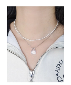 Close-up of double-layer necklace with white pearls and crystal pendant on silver chain