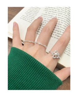 Detailed shot of S925 silver rings with flower pearl design on model's hand