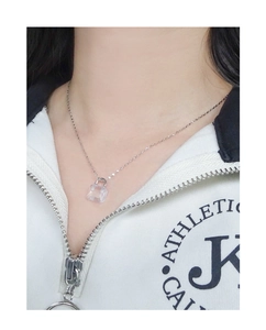 Detail view of S925 silver necklace with crystal handbag pendant on model's neck