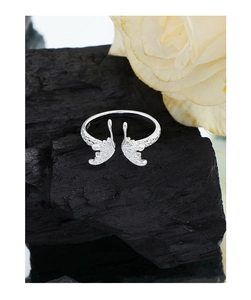 Macro view of S925 sterling silver butterfly ring with crushed metal texture on charcoal