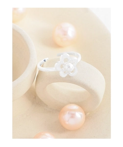 Macro shot of an adjustable S925 silver flower ring featuring a white pearl inlay