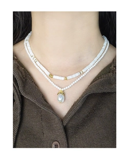Detail of layered S925 silver necklace with white pearls and baroque pearl pendant