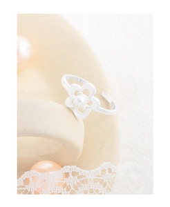 Detailed close-up of S925 sterling silver flower ring with white pearl on a lace background