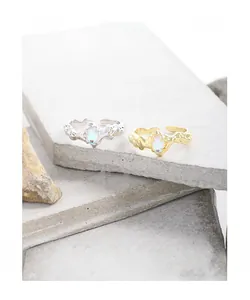 Detail view of silver and gold moonstone rings with irregular textured wave bands