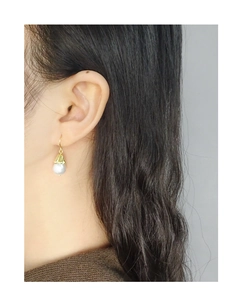 Close-up of S925 silver pearl drop earrings with gold textured cap on a female model