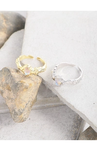 Detailed shot of gold and silver S925 sterling silver rings with iridescent moonstones