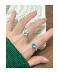 Close-up of S925 silver flower pearl and blue heart gemstone rings worn on fingers