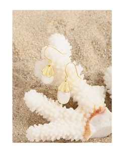Detailed shot of S925 silver shell pearl earrings hanging on white coral beach props