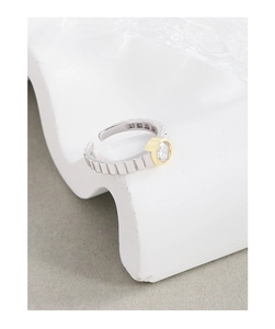 Detail of adjustable S925 silver gear ring with gold-edged zircon on white stone