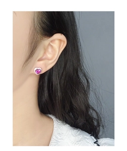 Close-up of S925 silver heart stud earring with red enamel and zircon on model ear