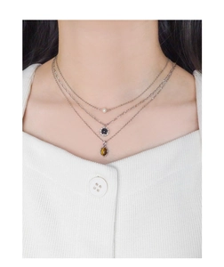 Close-up of triple-layered S925 silver necklace with pearl and tiger eye stone pendants