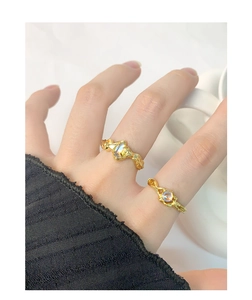 Detail of adjustable gold rings with irregular lava design and moonstone inlay