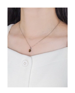 Close-up of S925 silver necklace with an oval brown tiger eye stone on a female model