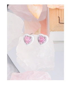 Macro detail of S925 silver heart stud earrings with pink zircon and white enamel
