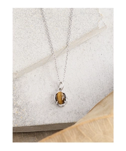 Close-up of S925 silver necklace with oval tiger eye stone pendant on natural stone