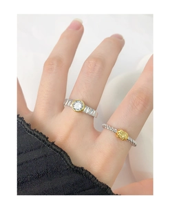 Close-up of stacked S925 silver rings with zircon inlay and golden gear logo details