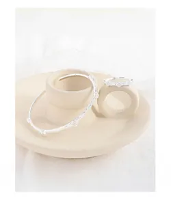 Close-up of S925 silver ring and cuff set featuring textured granular pattern detail