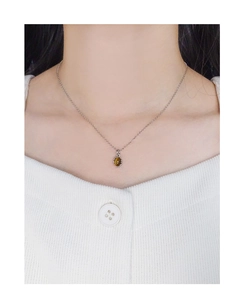 Close-up of an oval tiger eye stone pendant on a silver S925 necklace on a model