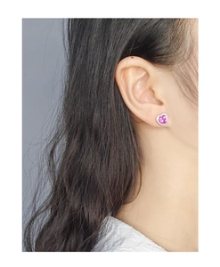 Close-up of S925 silver heart stud earrings with pink zircon and enamel coating on ear