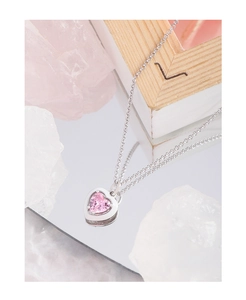 Detailed view of S925 silver heart necklace with pink zircon on a reflective surface