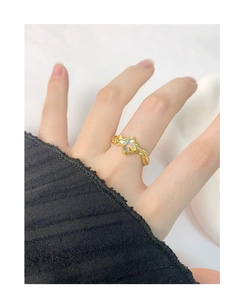 Close-up of irregular textured gold ring with iridescent moonstone on a hand
