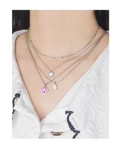 Close-up of layered S925 silver necklaces with pink heart crystal and opal pendants