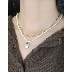 Elegant gold double layer necklace with bell orchid pearl pendant on a model