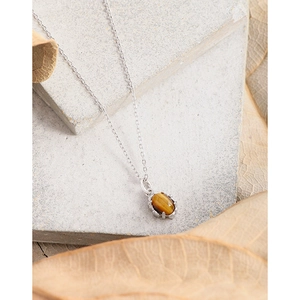 S925 sterling silver necklace with oval tiger eye stone pendant on a natural stone background