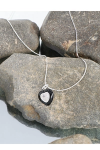 Close-up of heart pendant with clear zircon and black enamel on S925 silver chain