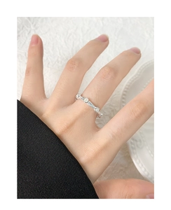 Detail of silver S925 ring with wrinkled texture and three white pearls on hand