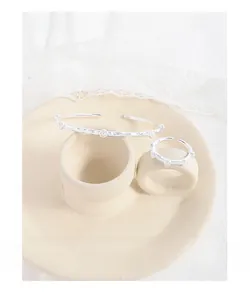 Macro view of silver cuff bracelet and ring set with wrinkled texture and pearls