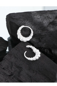 Gros plan de boucles d'oreilles créoles en argent 925 avec texture torsadée en spirale