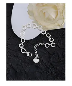 Detail of S925 sterling silver chain bracelet with heart pendant on black background