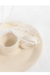 Close-up of S925 silver textured cuff bracelet with elegant pearl accents on lace