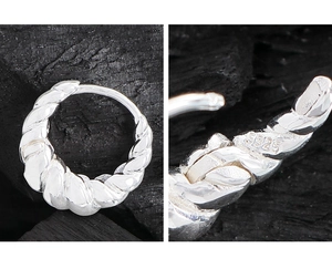 Détails macro des boucles d'oreilles croissant en argent S925 avec poinçon et texture torsadée