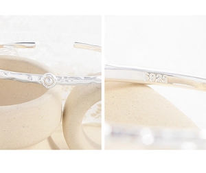 Macro detail of S925 sterling silver hallmark on hammered texture pearl bracelet