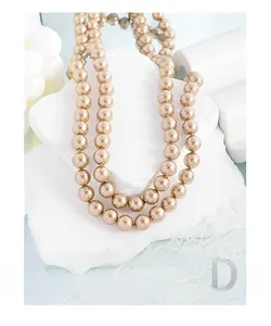 Close-up of double-layer champagne gold pearl necklace on an elegant stone display