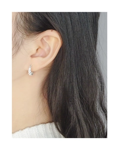 Gros plan de créoles torsadées en argent sterling S925 portées par un mannequin