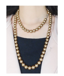 Close-up of double-layer champagne gold pearl necklace with silver clasp on a model