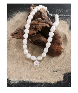 Détail d'un collier en perles baroques avec pendentif étoile de mer en argent et gemme rose