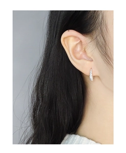 Gros plan de boucles d'oreilles torsadées en argent sterling S925 sur un mannequin