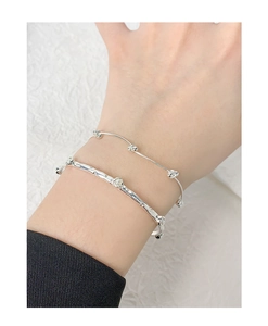 Detail of silver S925 bracelet set with irregular hammered texture and small pearls