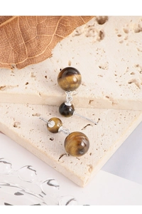 Détail macro du poinçon S925 sur des boucles d'oreilles en argent et oeil de tigre